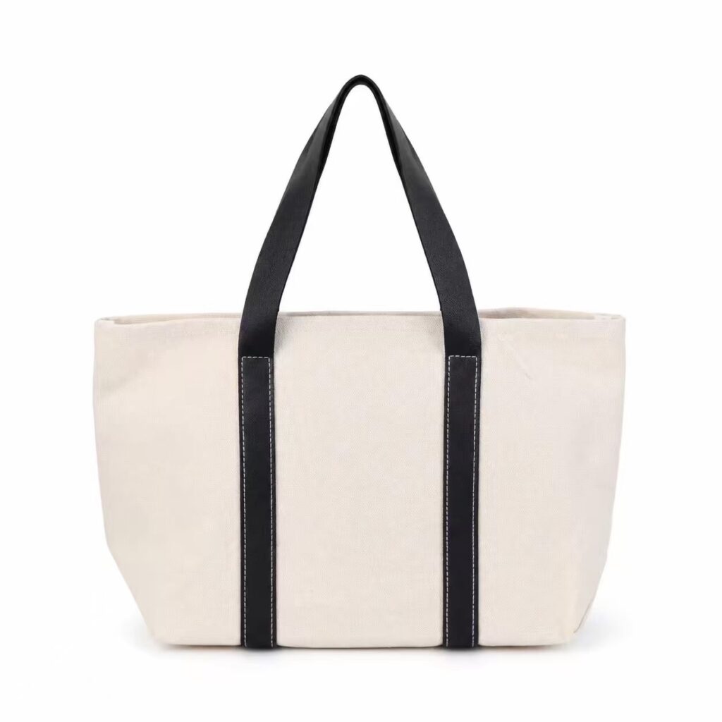 Natural-colour canvas tote bag with black handles and contrasting vertical straps