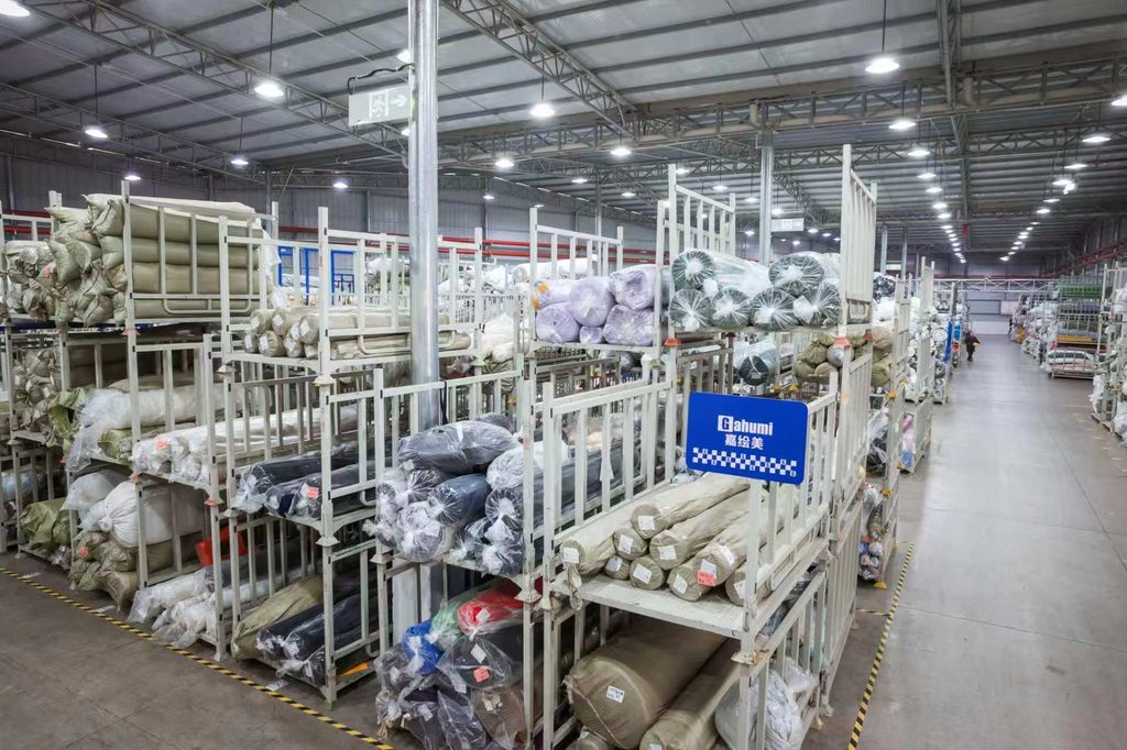 Wrapped fabric rolls arranged on storage racks in the Gahumi factory